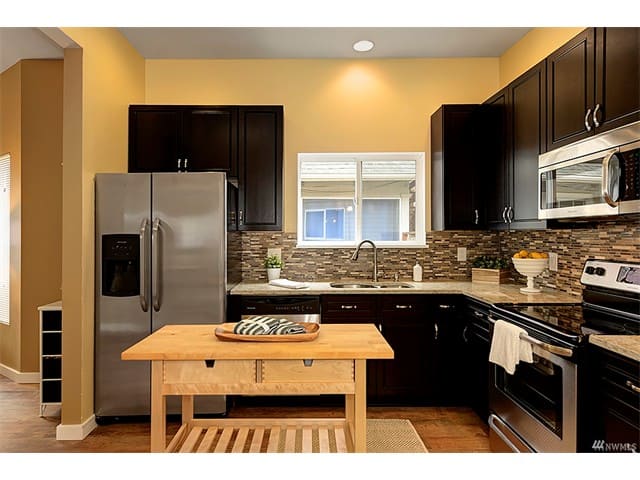residential kitchen dark cupboards countertop small table