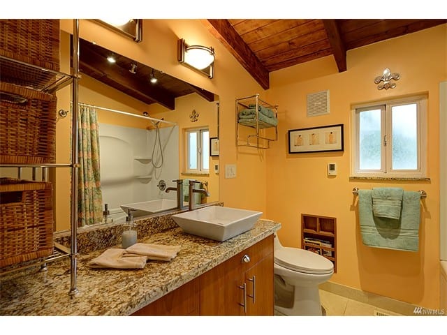 bathroom residential yellow peach walls towels toilet raised sink