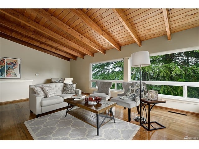 residential interior wooden beam ceiling couch chairs wooden coffee table hardwood floors