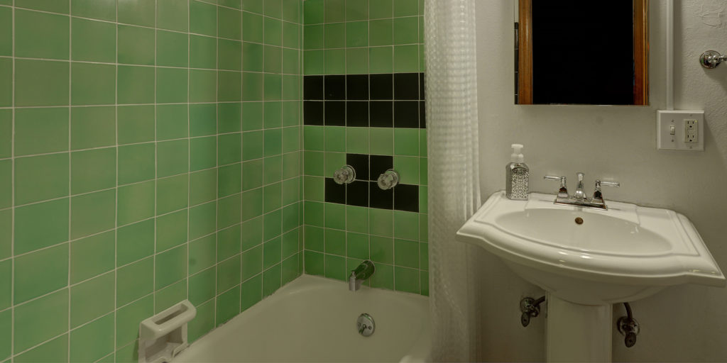 bathroom green tile white sink mirror