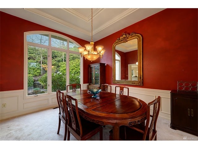 dining room red walls white ceiling trim chandelier window foliage view classic